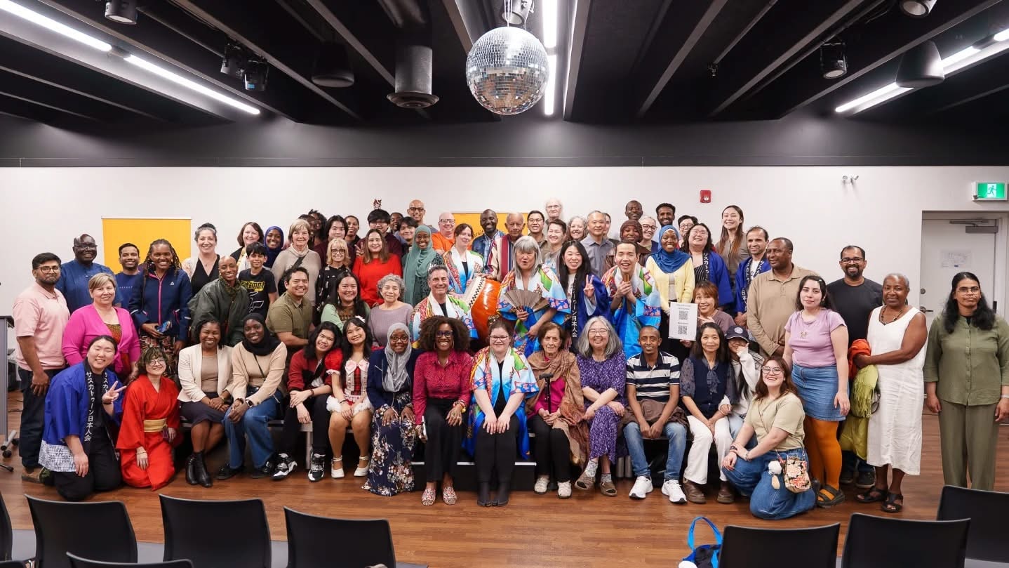Large group photo of workshop participants and community members posing together